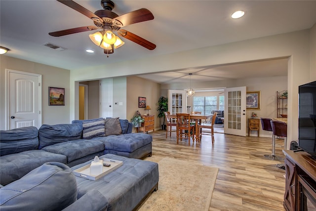 living room with recessed lighting, visible vents, light wood finished floors, and french doors