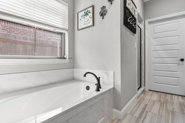 10009 Wildberry Dr, Waco, TX 76712 - bathroom with a shower stall, a wealth of natural light, a garden tub, and baseboards
