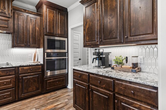 10009 Wildberry Dr, Waco, TX 76712 - kitchen with built in microwave, crown molding, dark brown cabinetry, backsplash, and stainless steel oven