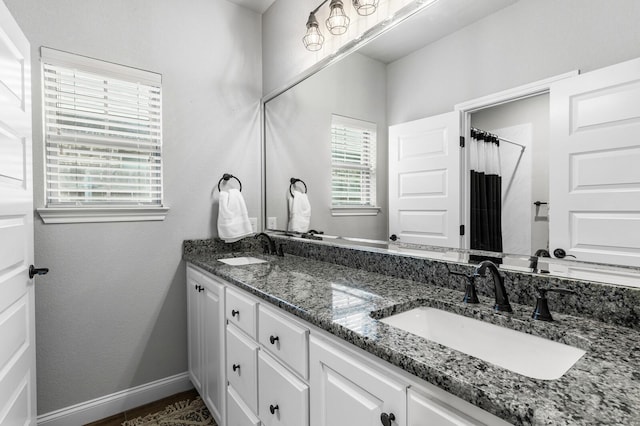 10009 Wildberry Dr, Waco, TX 76712 - full bath featuring a sink, double vanity, curtained shower, and baseboards