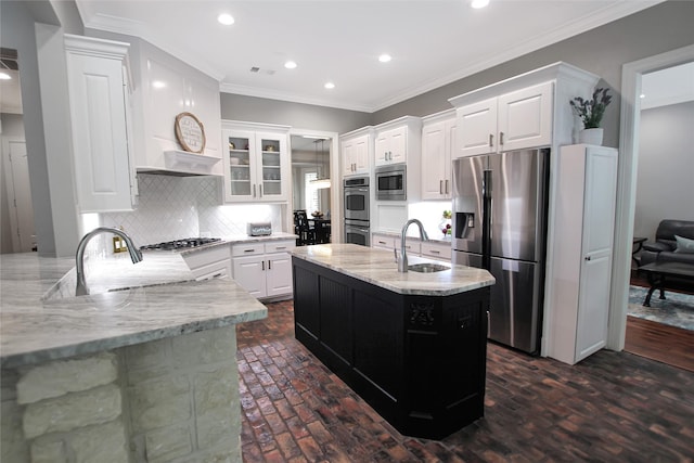 kitchen with light stone counters, a sink, backsplash, appliances with stainless steel finishes, and recessed lighting