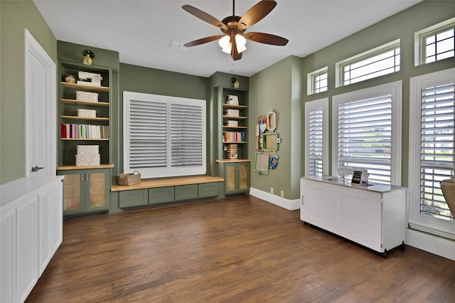 home office featuring baseboards, a ceiling fan, built in features, and dark wood-type flooring