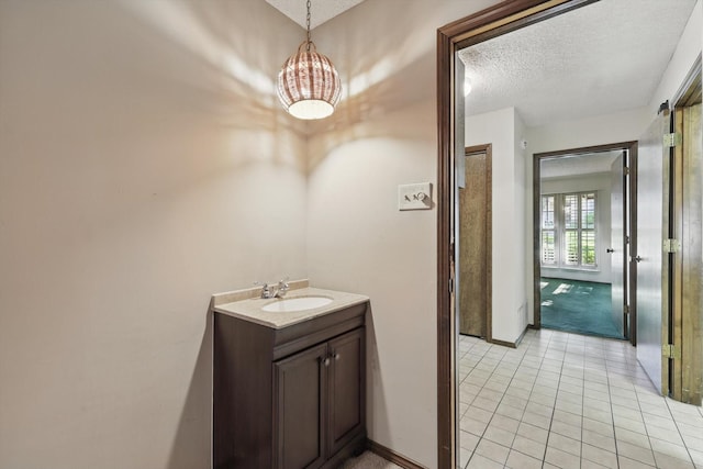 5112 River Ridge Rd, Arlington, TX 76017 - bathroom featuring a textured ceiling, tile patterned flooring, a chandelier, vanity, and baseboards
