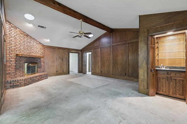 5112 River Ridge Rd, Arlington, TX 76017 - unfurnished living room with wooden walls, a ceiling fan, a brick fireplace, light carpet, and a sink