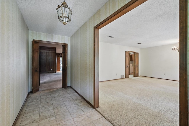 5112 River Ridge Rd, Arlington, TX 76017 - hallway featuring a chandelier, wallpapered walls, baseboards, and a textured ceiling