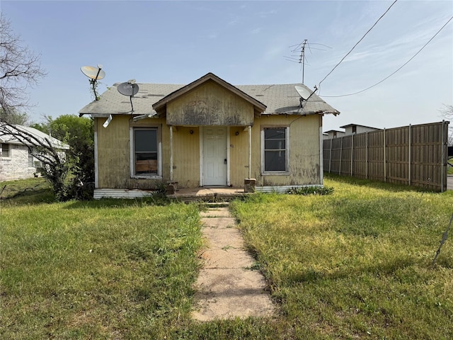 bungalow-style house featuring fence and a front yard