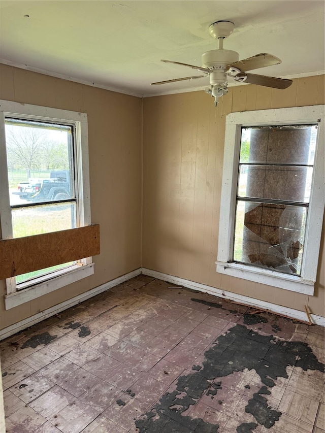 unfurnished room featuring ceiling fan and baseboards