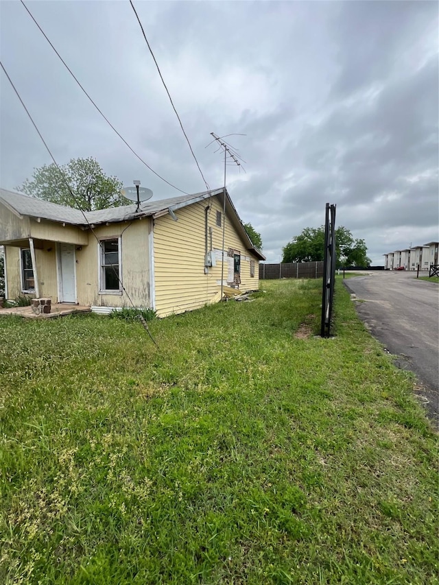 view of home's exterior featuring a yard and fence