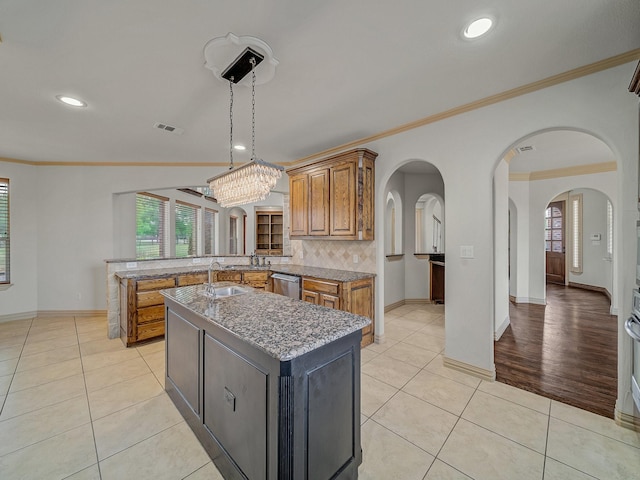 kitchen with brown cabinets, ornamental molding, and plenty of natural light