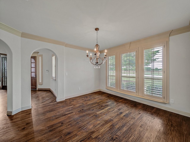 unfurnished dining area featuring ornamental molding, arched walkways, a notable chandelier, and dark wood-style floors