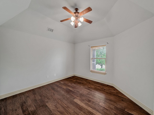 spare room with lofted ceiling, visible vents, a ceiling fan, dark wood-type flooring, and baseboards