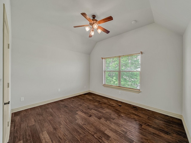 empty room with ceiling fan, lofted ceiling, wood finished floors, and baseboards