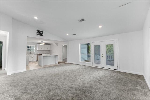 1125 Rodeo Center Blvd, Mesquite, TX 75149 - unfurnished living room with vaulted ceiling, light colored carpet, baseboards, recessed lighting, and french doors