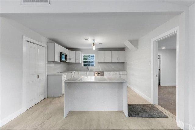 1125 Rodeo Center Blvd, Mesquite, TX 75149 - kitchen with stainless steel appliances, a center island, light countertops, white cabinets, and baseboards
