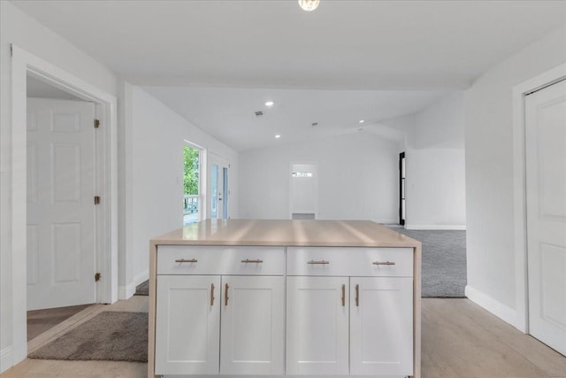 1125 Rodeo Center Blvd, Mesquite, TX 75149 - kitchen featuring lofted ceiling, white cabinetry, baseboards, light countertops, and light wood-type flooring