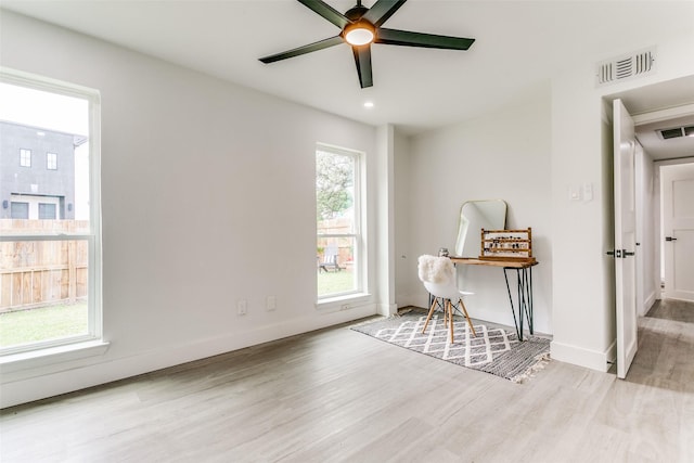 office area with wood finished floors, visible vents, a ceiling fan, and baseboards