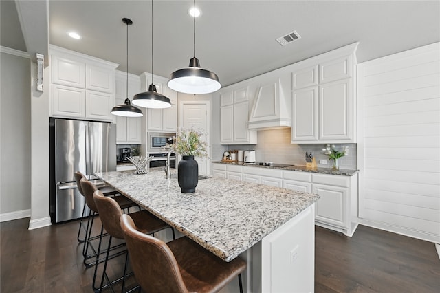 kitchen featuring stainless steel appliances, baseboards, custom range hood, dark wood-type flooring, and backsplash