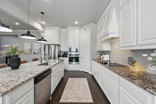 kitchen with stainless steel appliances, a sink, custom range hood, white cabinets, and recessed lighting