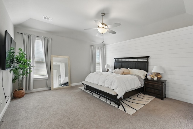 bedroom featuring carpet floors, ceiling fan, baseboards, and wood walls