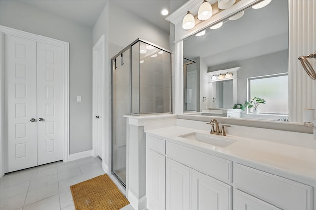 bathroom with a stall shower, tile patterned floors, and vanity