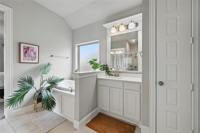 bathroom featuring a garden tub, a stall shower, vaulted ceiling, vanity, and tile patterned flooring
