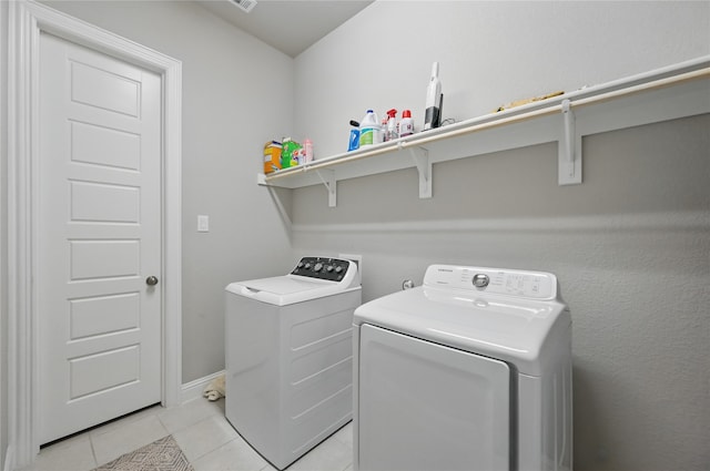 washroom with washer and clothes dryer, light tile patterned flooring, and baseboards