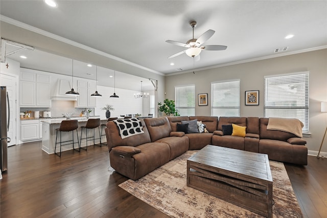 living area with ceiling fan, dark wood-style flooring, recessed lighting, ornamental molding, and a chandelier