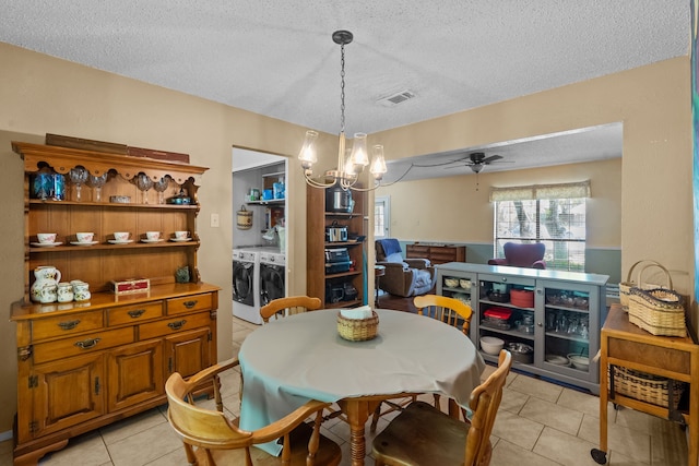 dining area with a textured ceiling, ceiling fan with notable chandelier, light tile patterned floors, washer and dryer, and visible vents