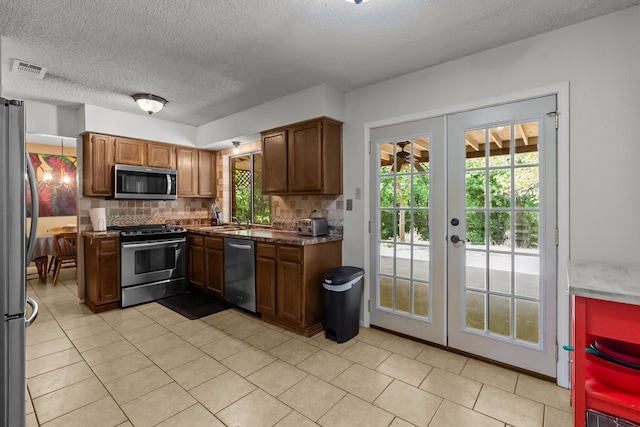 kitchen featuring backsplash, visible vents, appliances with stainless steel finishes, and french doors