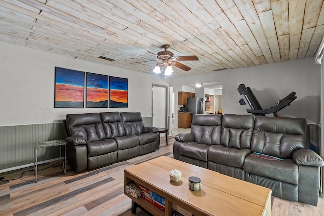 living area with light wood-type flooring, a ceiling fan, visible vents, and wood ceiling