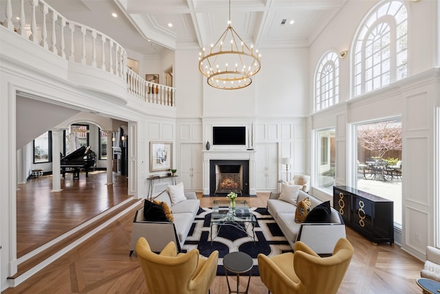 13 Downs Lake Cir, Dallas, TX 75230 - living area featuring a towering ceiling, a fireplace with flush hearth, coffered ceiling, a chandelier, and crown molding