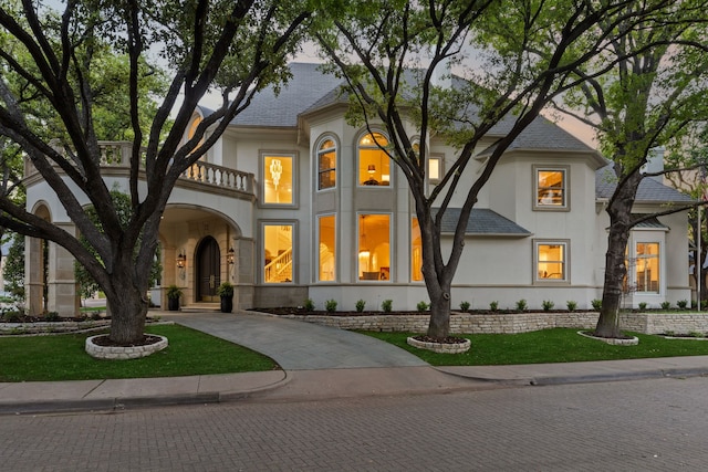 13 Downs Lake Cir, Dallas, TX 75230 - view of front of house featuring stucco siding, a balcony, a front lawn, and roof with shingles