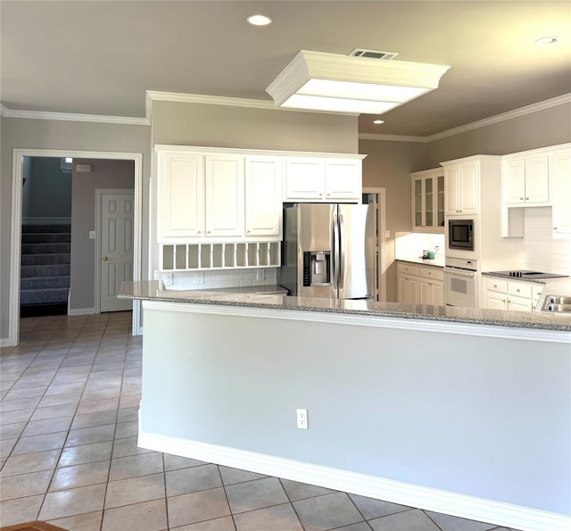 611 Twin Creek Dr, Allen, TX 75013 - kitchen with stainless steel fridge with ice dispenser, white oven, built in microwave, light stone countertops, and light tile patterned floors