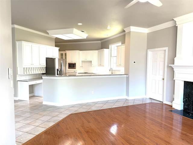 611 Twin Creek Dr, Allen, TX 75013 - kitchen with appliances with stainless steel finishes, light tile patterned flooring, decorative backsplash, ornamental molding, and a peninsula