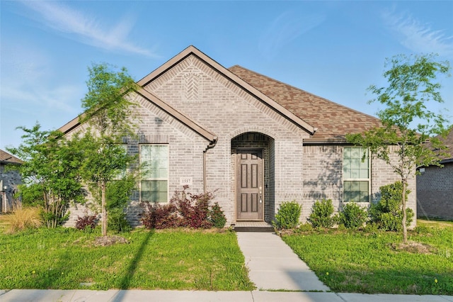 view of front of house featuring a front lawn and brick siding
