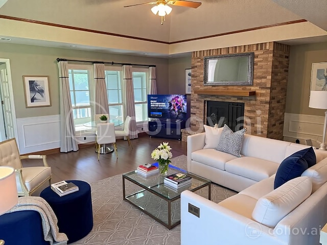 living room with a wainscoted wall, wood finished floors, ceiling fan, and a decorative wall