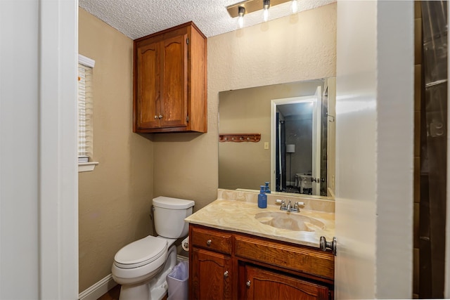 bathroom featuring a textured ceiling, vanity, and toilet