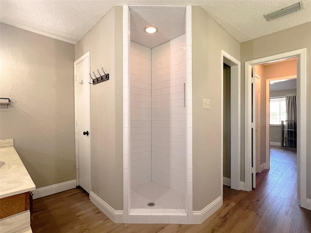 bathroom with visible vents, wood finished floors, and a textured ceiling