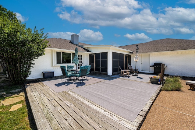 deck with area for grilling, outdoor dining area, and a sunroom