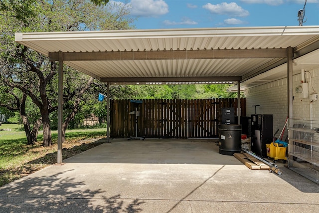 view of car parking featuring fence and a carport