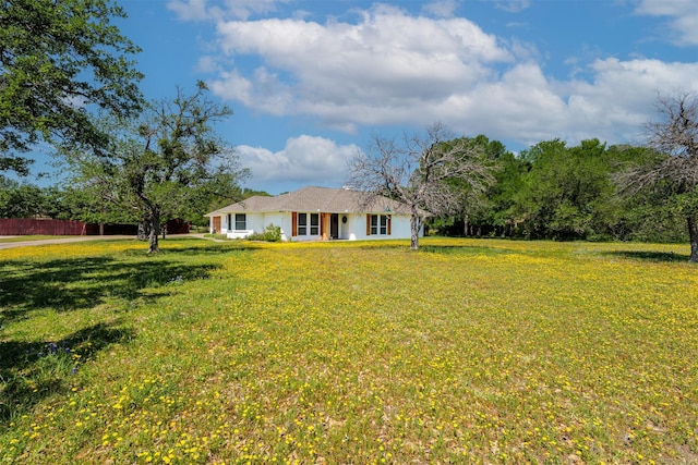 view of front of home with fence and a front lawn