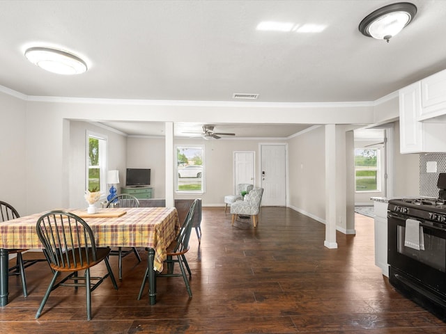 dining space featuring visible vents, ornamental molding, dark wood-style flooring, baseboards, and ceiling fan