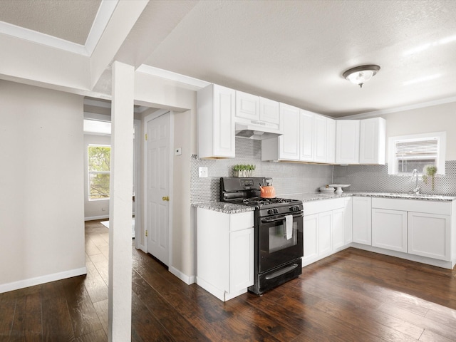 kitchen featuring under cabinet range hood, gas stove, backsplash, and white cabinetry