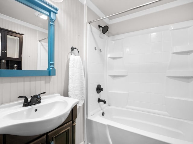 full bath featuring shower / bathing tub combination, vanity, wood walls, and ornamental molding