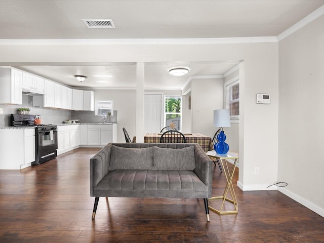interior space with baseboards, dark wood-style flooring, crown molding, and visible vents