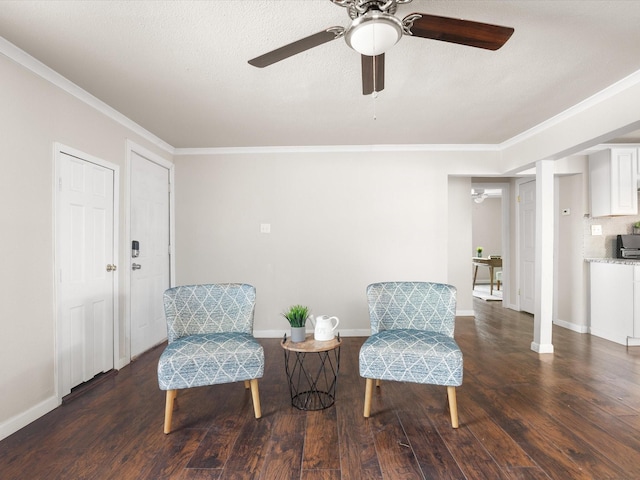 living area with baseboards, a ceiling fan, wood finished floors, and crown molding