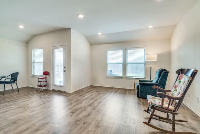 sitting room featuring vaulted ceiling, a healthy amount of sunlight, wood finished floors, and baseboards