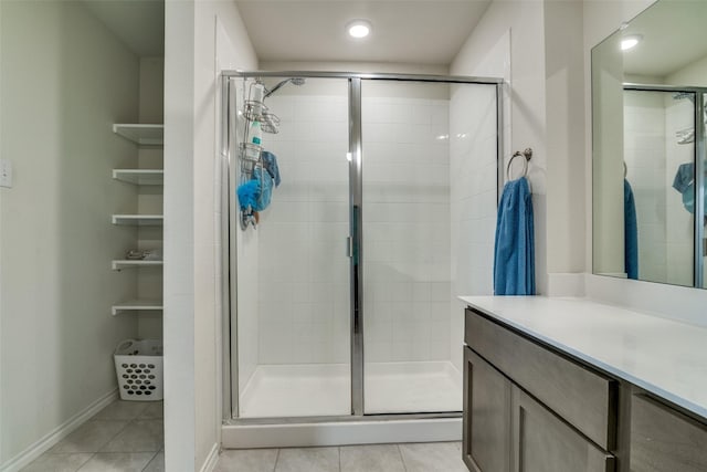 full bathroom featuring baseboards, vanity, tile patterned floors, and a stall shower