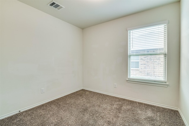 unfurnished room featuring carpet floors, visible vents, and baseboards
