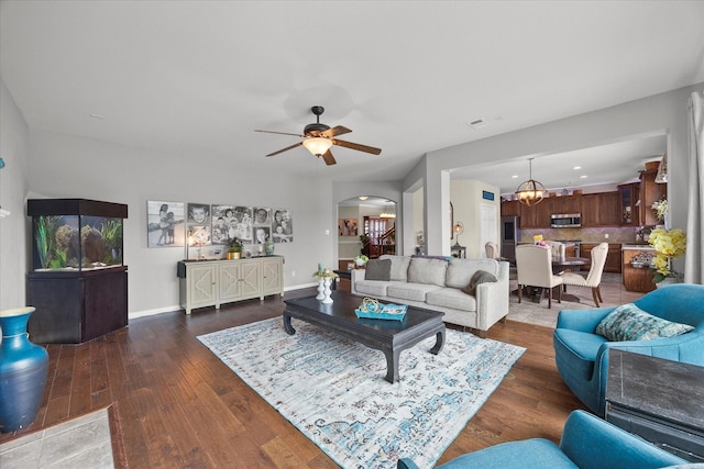 living room with arched walkways, baseboards, recessed lighting, ceiling fan with notable chandelier, and wood-type flooring